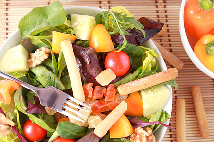 Salad containing salad, fork, and bread sticks