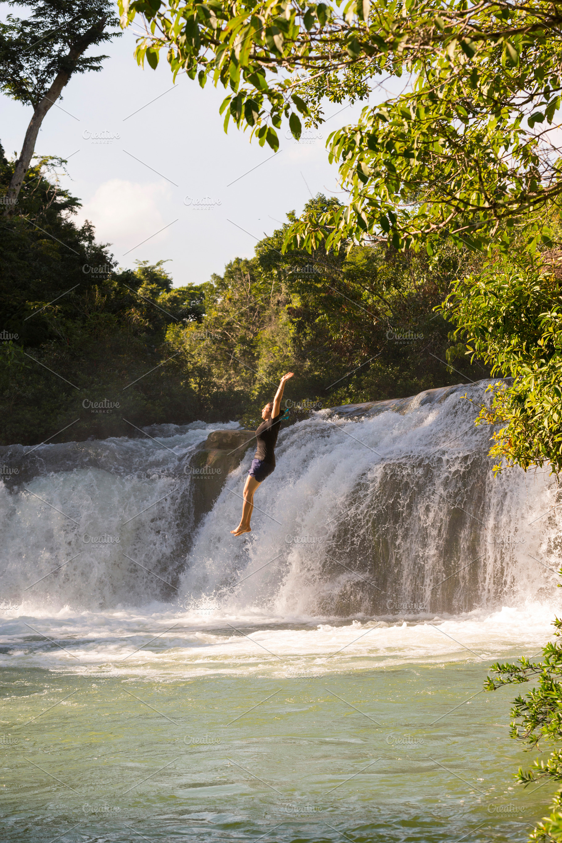 Adventure Traveller Jumping Off Waterfall In Belize, a Person Photo by THP Creative