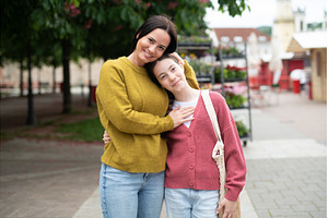 Mother embracing daughter while, a Person Photo by HalfPoint