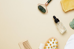 Beauty care arrangement featuring marble roller, gua sha, wooden body brush, fa, a Photo by matucha