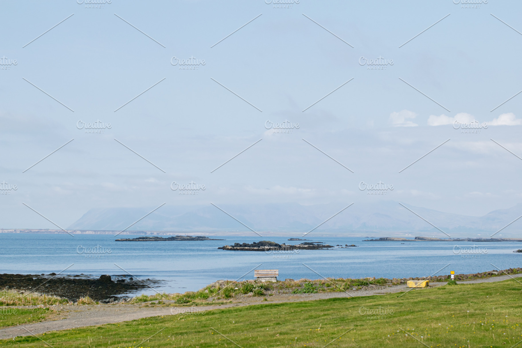 Scenic coastal view of grassy landscape with islands, distant mountains, and a, a Photo by AS photostudio