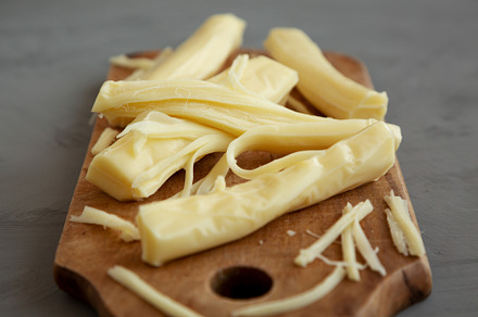 Organic String Cheese on a rustic wooden board on a gray backgro, a Food & Drink Photo by LiudmylaChuhunova