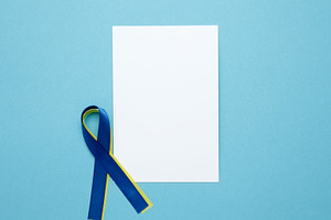 White notebook mockup. A yellow and blue awareness ribbon, symbolizing World Do, a Photo by matucha