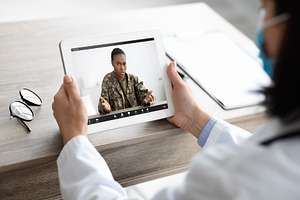 Telemedicine Concept. Military Woman Having Video Call With Therapist Lady, a Photo by Prostock-Studio