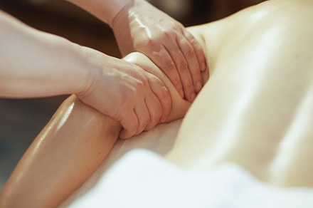 Massage therapist in massage cabinet massaging clients arm, a Photo by Alliance Images