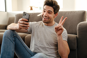 Happy man with smartphone having video call