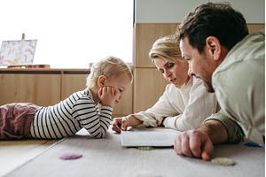 Parents reading book with little son, a Person Photo by HalfPoint