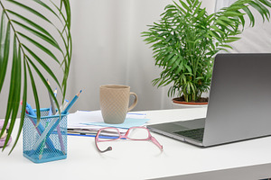 Modern workplace with open laptop, cup of coffee, pink glasses a, a Technology Photo by ndanko