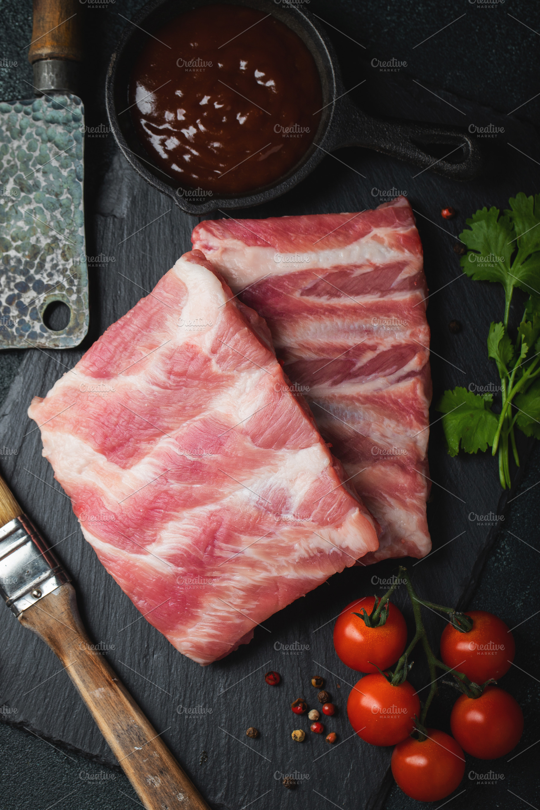Raw meat. Raw pork ribs from the back with meat on a black background. backgrou, a Food & Drink Photo by Budarinphoto