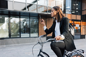 Businesswoman sitting on bicycle, a Business Photo by Artem Varnitsin