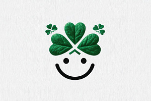 Minimalist smiley face with green clover leaves as hair on white, an Abstract Photo by José Manuel Gelpi