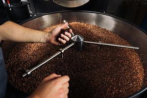 Unrecognizable male grabs beans, an Industrial Photo by Artem Varnitsin