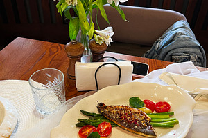 Elegant meal featuring grilled fish with vegetables and a floral table centerpi, a Photo by AS photostudio