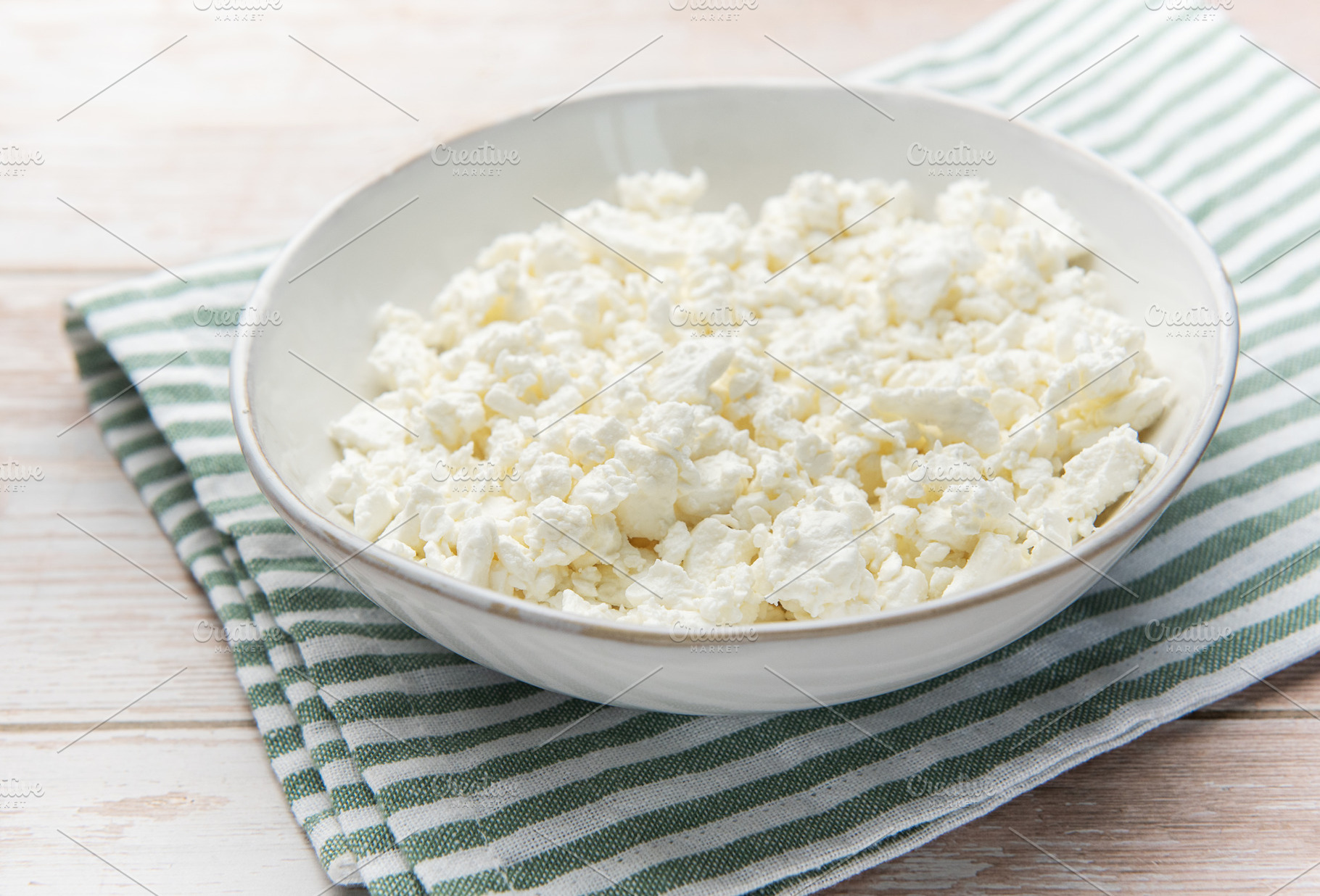 Cottage cheese in bowl on wooden table with green napkin, a Food & Drink Photo by Olena Rudo