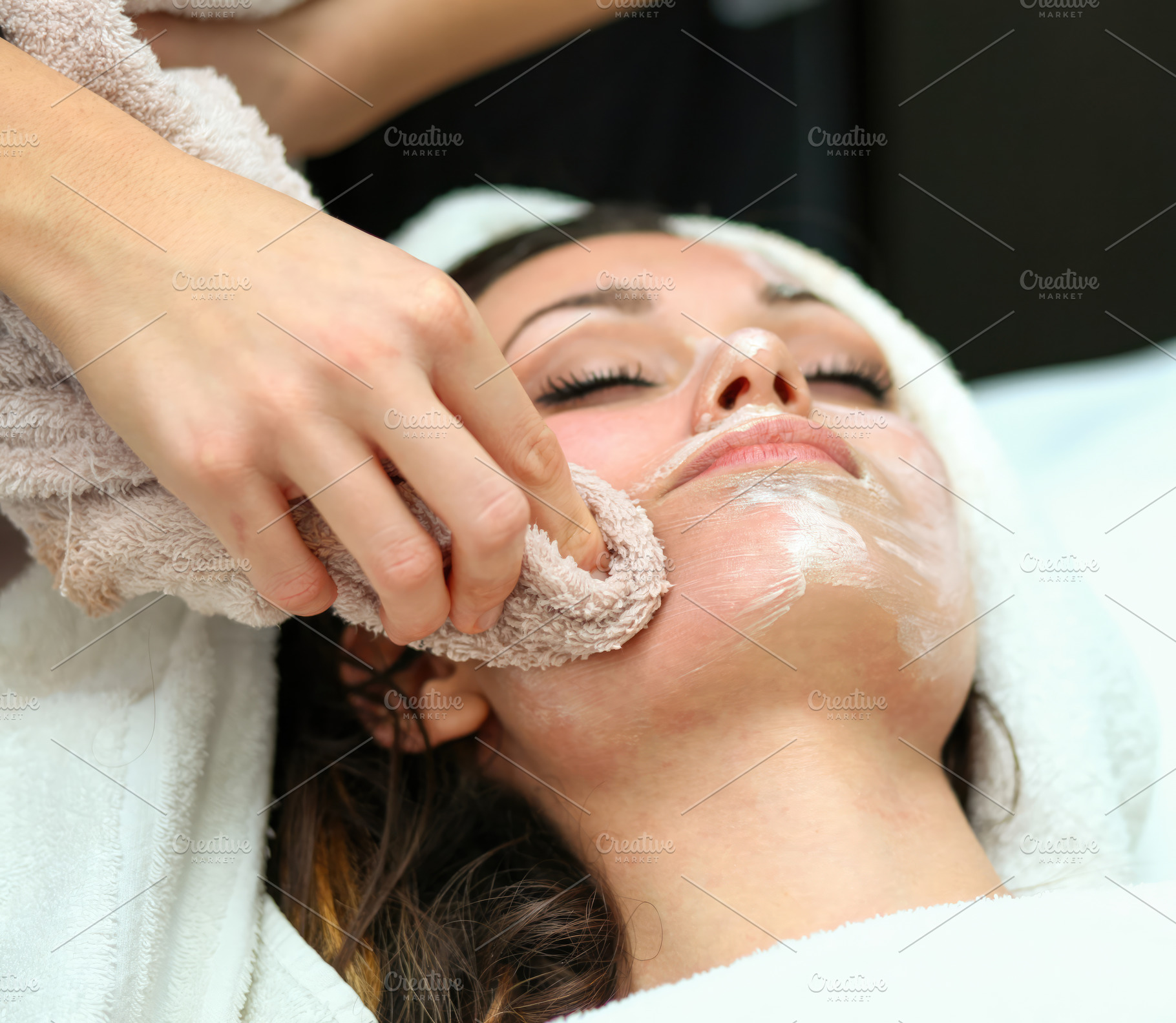 Beautician removing face mask with towel from young woman's face, an Abstract Photo by Antonio Gravante Market