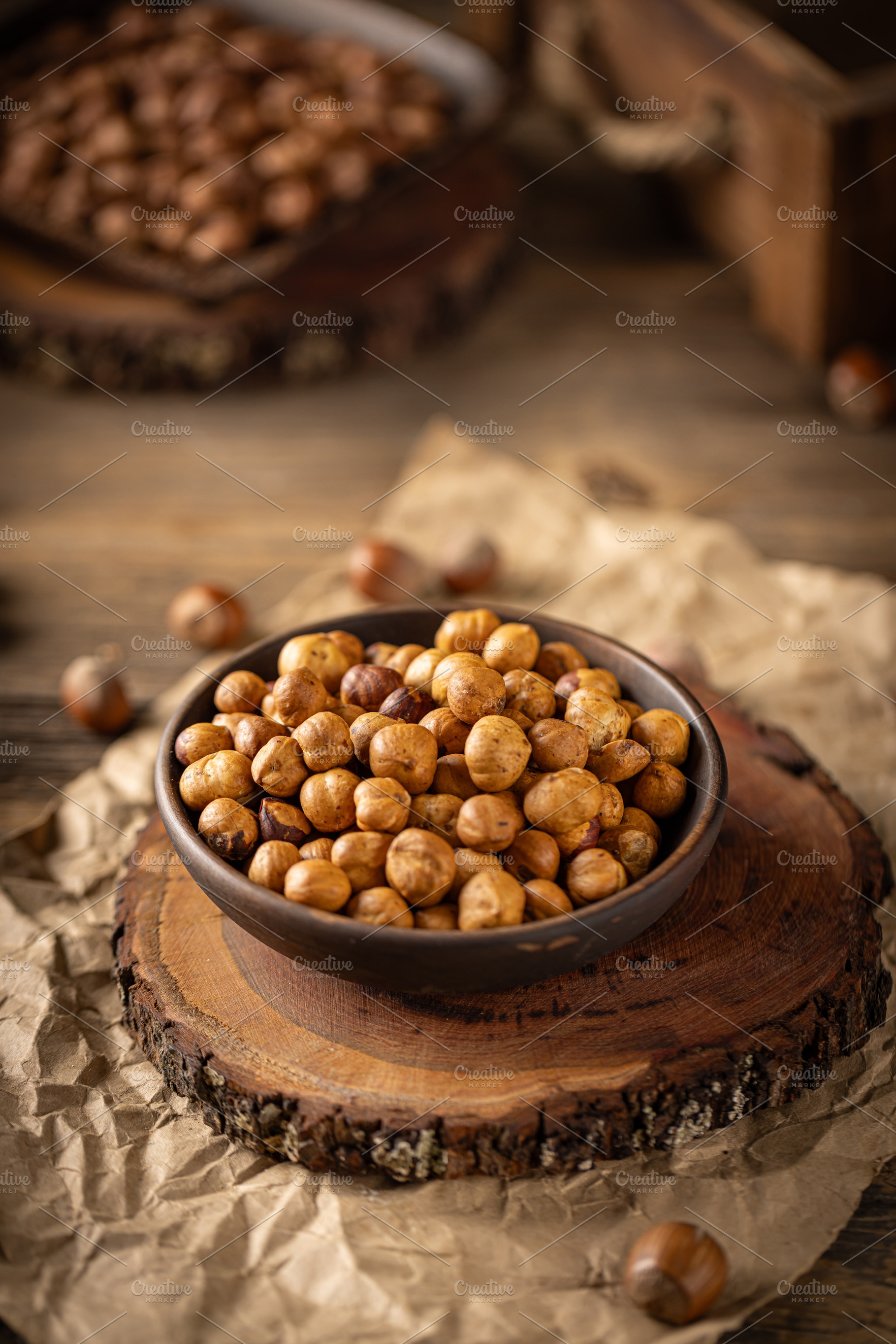 Shelled hazelnuts in a bowl placed on a wooden board, a Photo by Grafvision photography