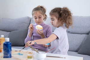 Two sisters decorating Easter eggs., a Person Photo by etorres69