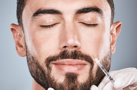 Face injection, man and plastic surgery for skincare, collagen and beauty clinic in studio. Cosmetics, needle and male aesthetic for body transformation, botox change and facial prp on background, a Photo by Peopleimages.com