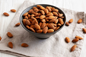 Roasted Almonds in a Bowl, side view., a Food & Drink Photo by LiudmylaChuhunova