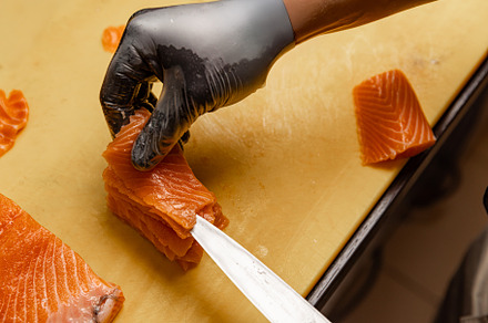 Chef arranging slices of fresh salmon