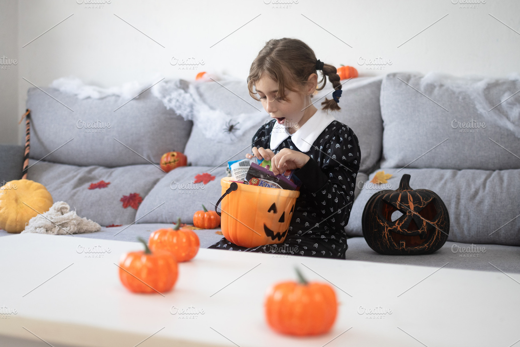 Girl opening Halloween candy bucket with surprised face, a Person Photo by etorres69
