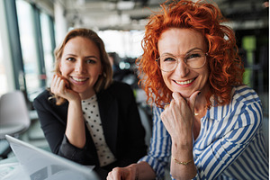 Two female colleagues analyzing, a Business Photo by HalfPoint