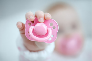 A pacifier is held by baby hands, a Person Photo by ZinetroN