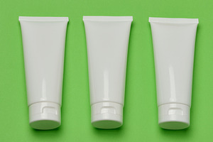 Three empty white plastic tubes for cosmetics or cream arranged, a Beauty & Fashion Photo by ndanko