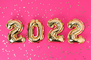 New Year 2022. Foil balloons numbers 2022 on pink background. New Year Christma