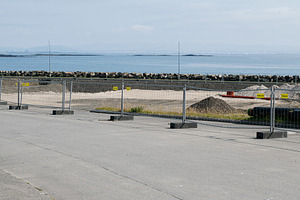 Coastal construction site with barriers and a scenic ocean view in Akranes, a Photo by AS photostudio