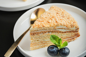 Medovik. Honey cake made from honey cakes with whipped sour cream, decorated wi, a Food & Drink Photo by Budarinphoto
