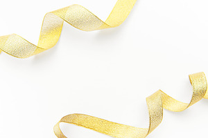 Gold glitter ribbon creating elegant border on white, a Holiday Photo by Olena Rudo
