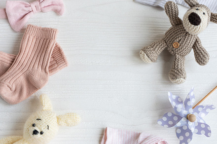 Baby clothes with knitted toys dog and rabbit, toy windmills and, a Beauty & Fashion Photo by Olena Rudo