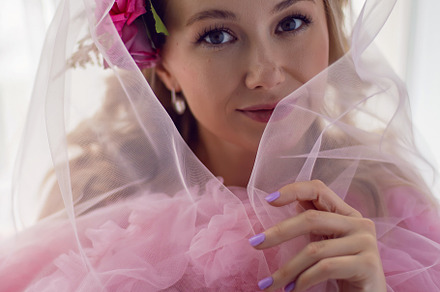 portrait of a fashionable blonde woman in a pink dress and rose flower in her h, a Person Photo by SaulichPhoto