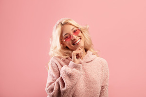Happy young lady touching chin and smiling at camera, wearing stylish colorful, a Photo by Prostock-Studio