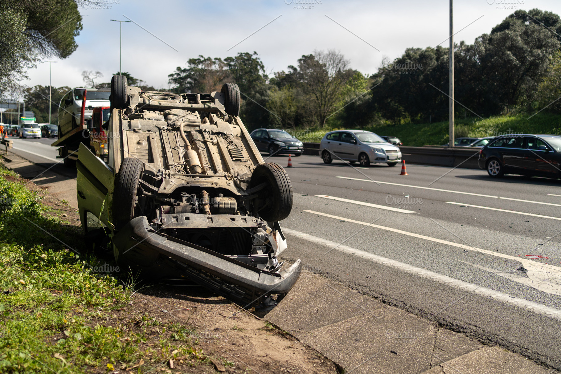 Damaged wrecked car after accident lying upside down on roadside, a Photo by andreonegin market