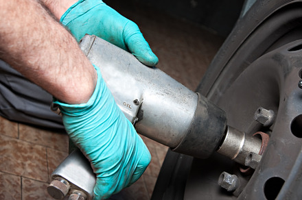 Mechanic changing wheel on car with impact wrench. mechanic man, a Transportation Photo by FoodStock