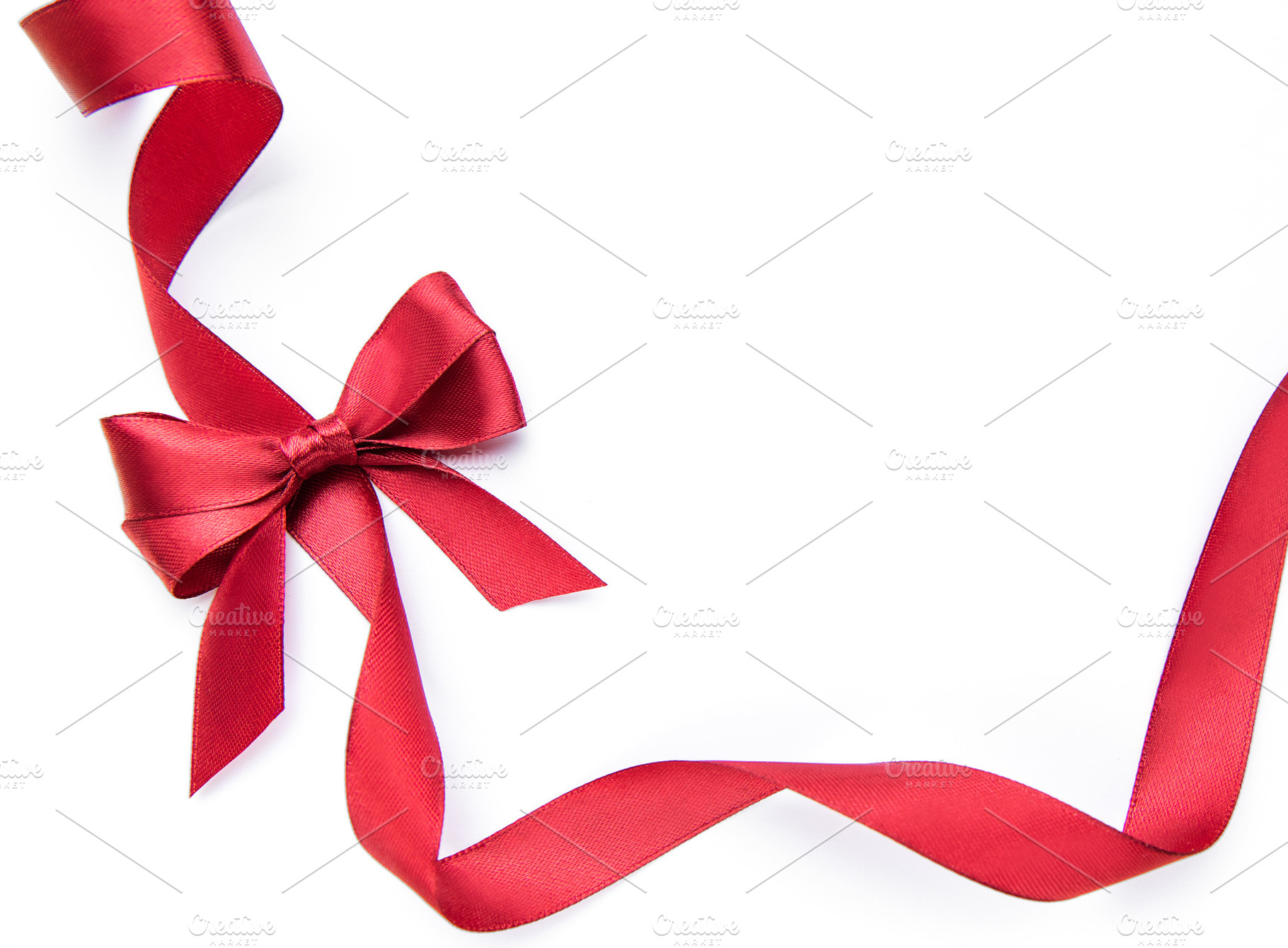 Red ribbon bow forming gift border on white, a Holiday Photo by Olena Rudo