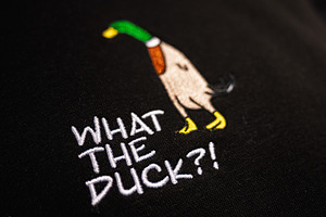 Colorful Embroidery of Duck on Black Fabric with Humorous Text, What the Duck?!, a Photo by AS photostudio