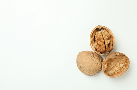 Walnuts with nutshell on white background, close up, a Food & Drink Photo by AtlasStudio PRO