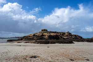 Rocky tidal island exposed at low tide in Tregastel, Brittany, F, a Nature Photo by GoodGoods
