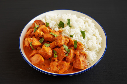 Homemade Easy Indian Butter Chicken with Rice on a Plate on a bl, a Food & Drink Photo by LiudmylaChuhunova