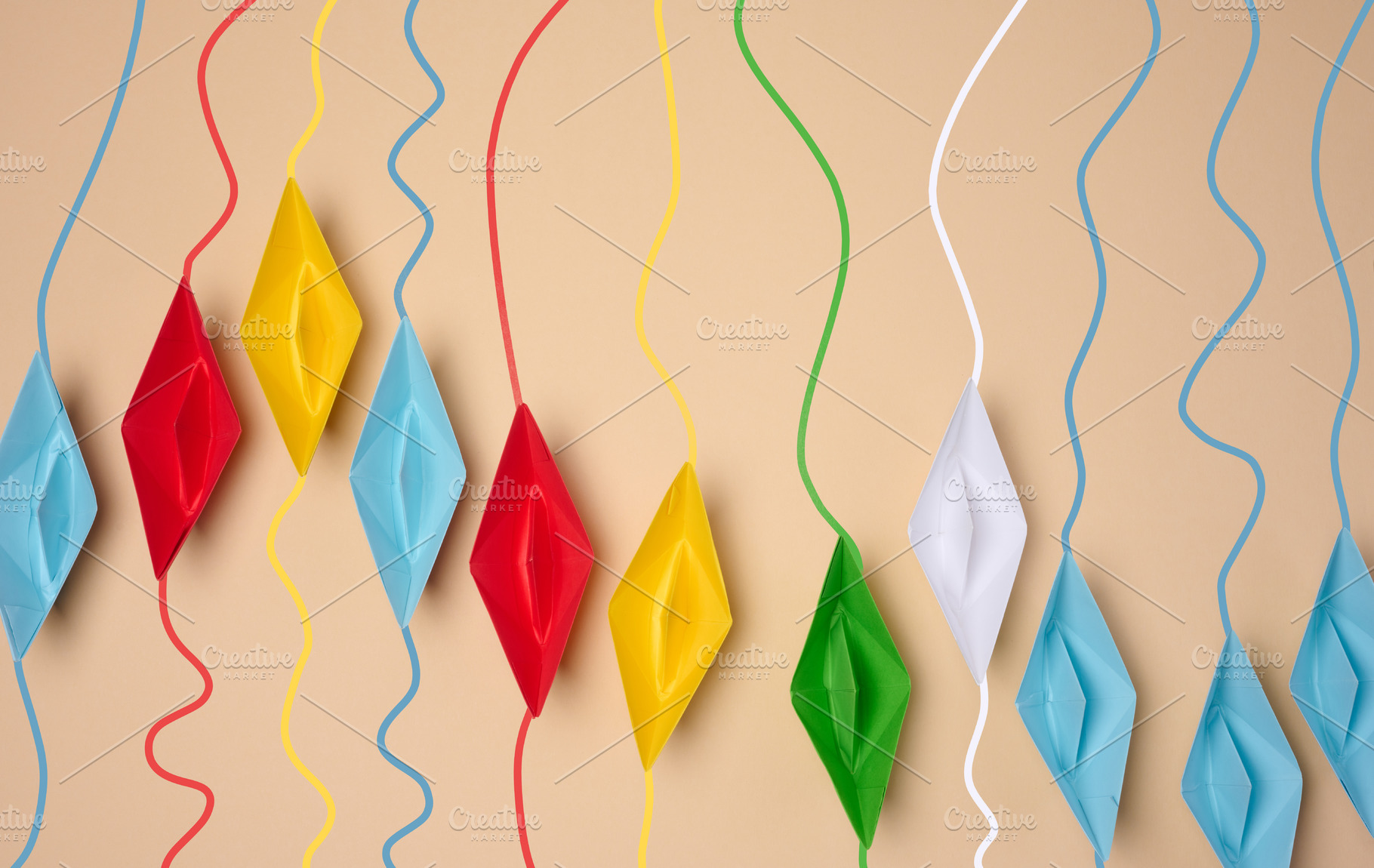 A row of multicolored origami paper boats with corresponding col, a Business Photo by ndanko