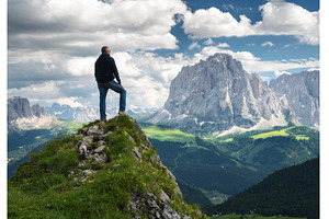 Hiker standing on a peak, a Nature Photo by den-belitsky