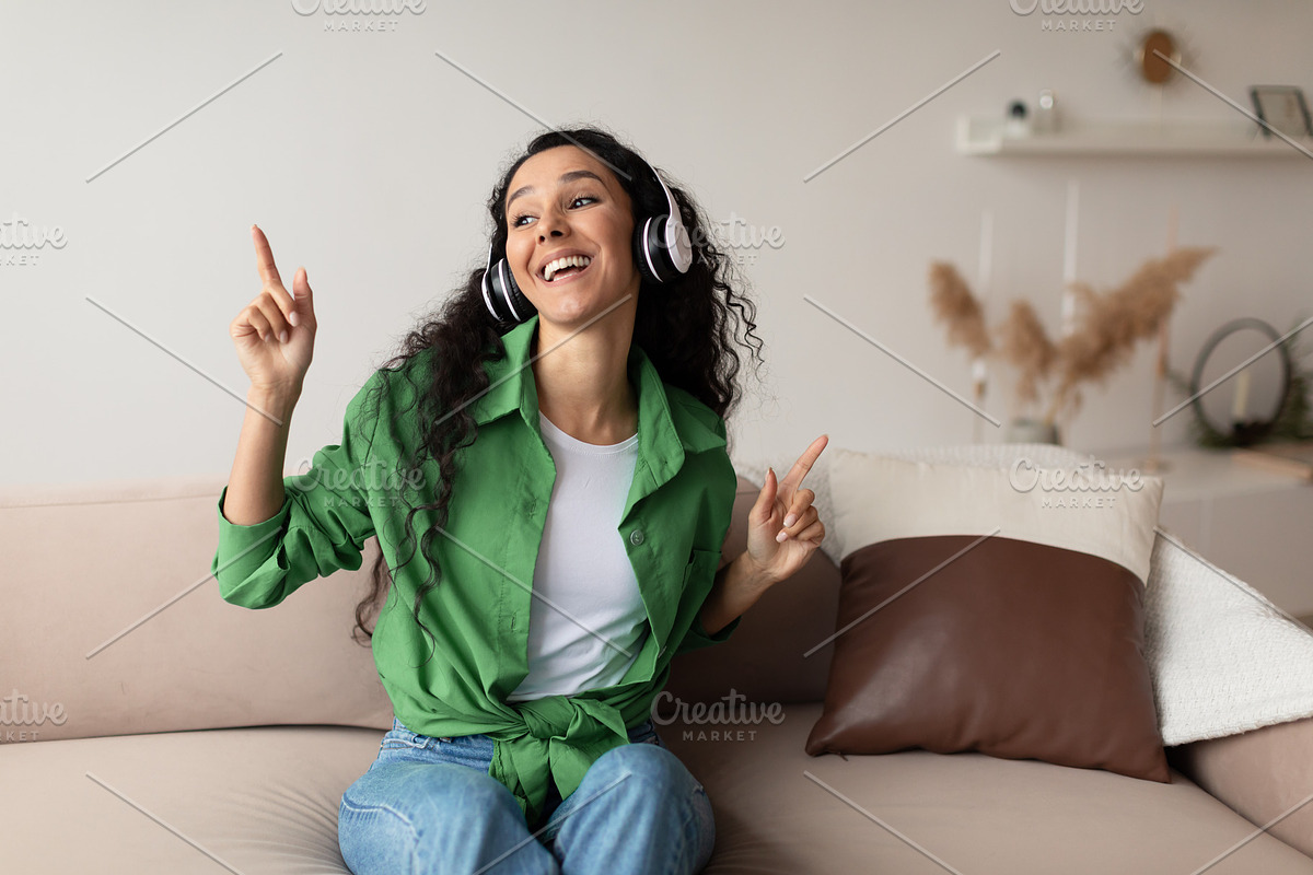 Middle Eastern Lady Wearing Headphones Listening To Music At Home, a Photo by Prostock-Studio (Photo 2 of 3)