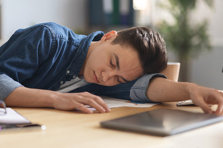 Overworking Concept. Young Male Employee Sleeping At Desk In Office