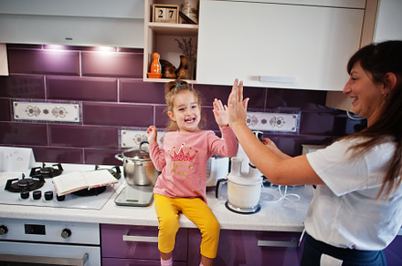 Mother with daughter cooking at kitchen, happy children's moment, a Person Photo by AS photostudio