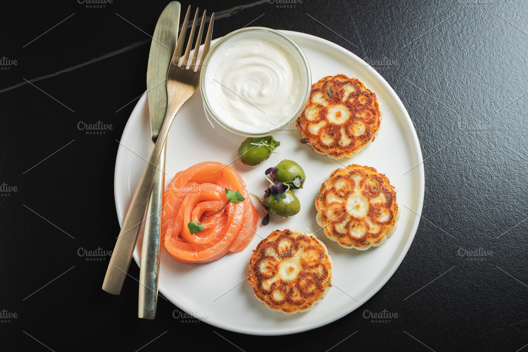 Savory Syrniki with Smoked Salmon, Olives and Sour Cream on White Plate, a Food & Drink Photo by Budarinphoto