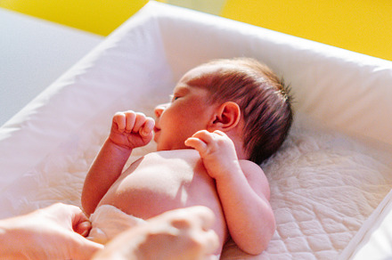 A newborn being changed on a baby changer, a Person Photo by rubenchase