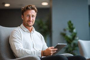 Man sitting in chair using tablet, a Photo by Beautiful things